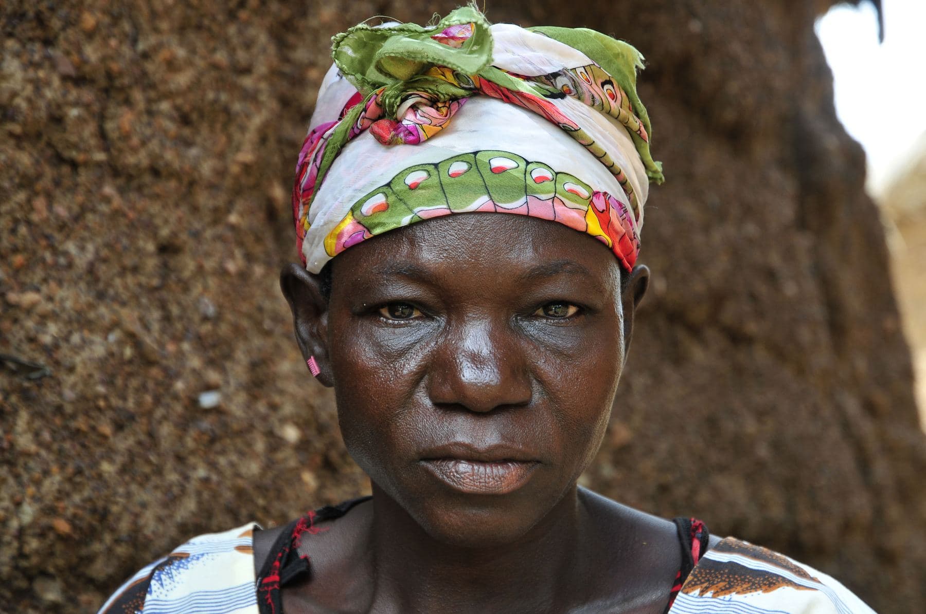 A farmer standing at her home in Ghana