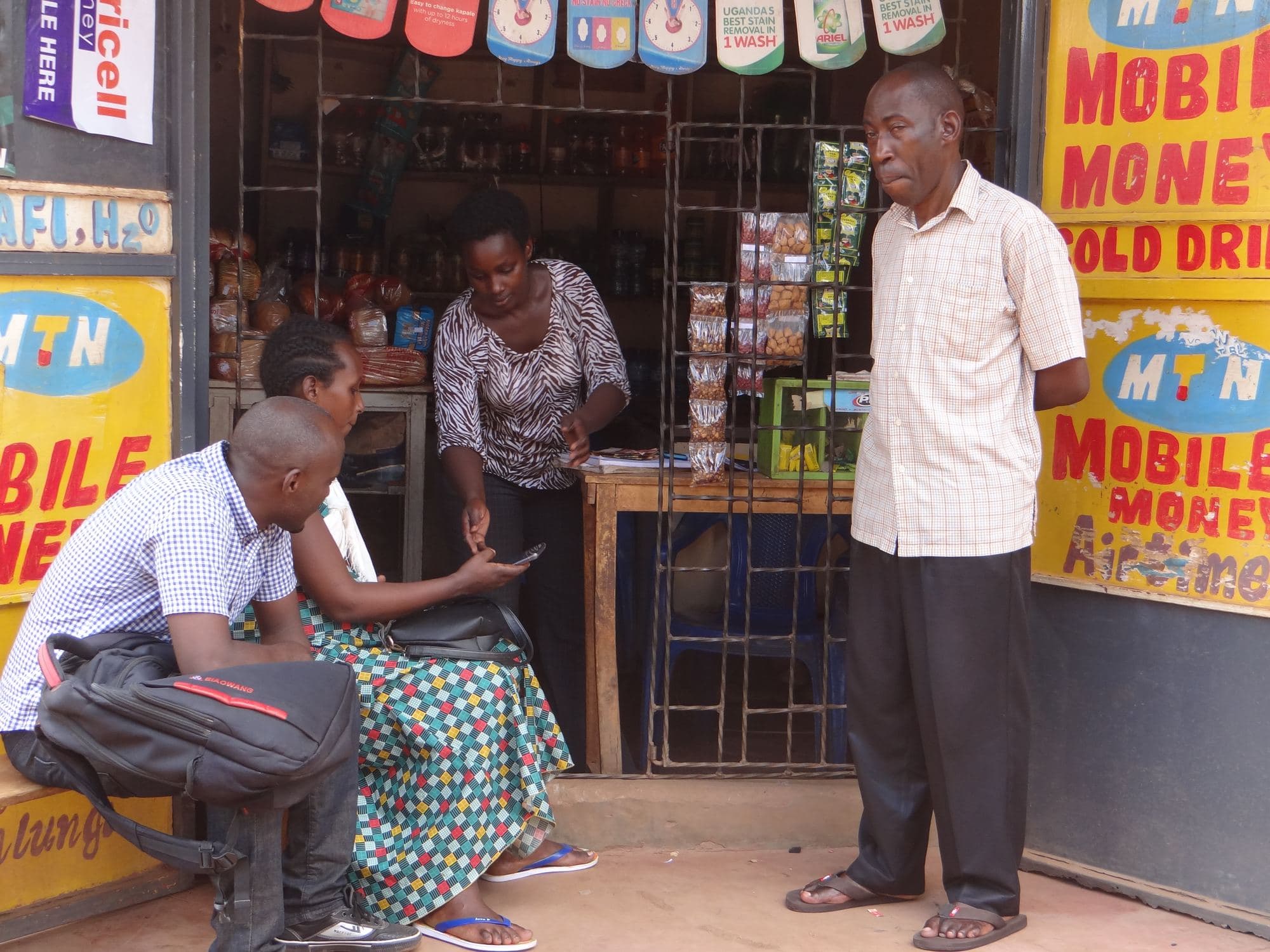 A farmer completing a mobile money transaction at a local outlet